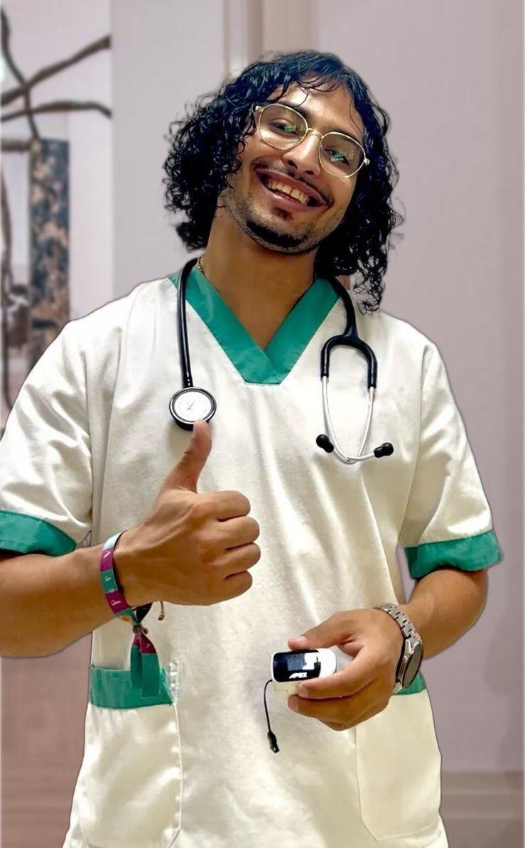Achraf, enfermero profesional con estetoscopio sonriendo con el pulgar arriba